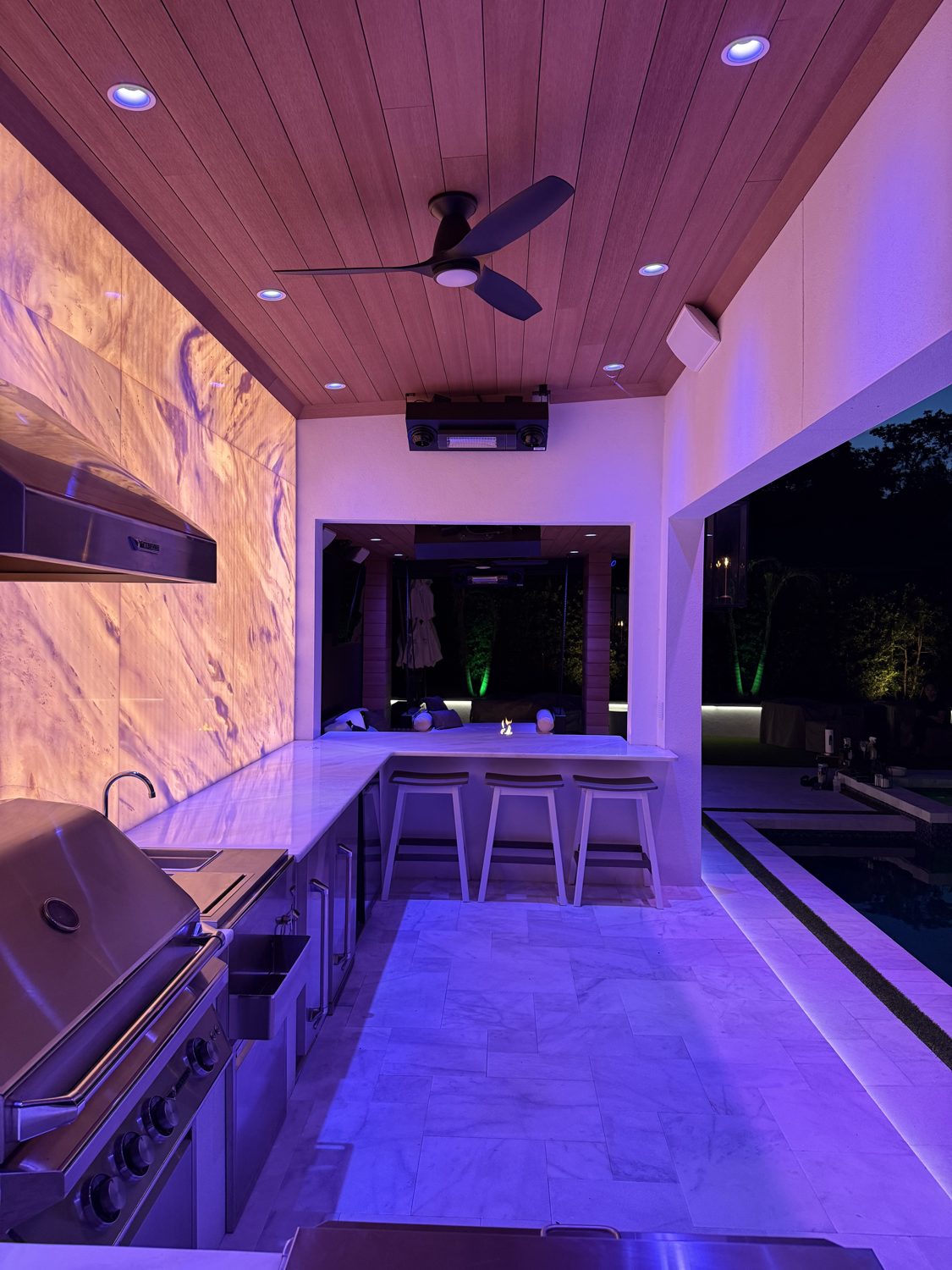 Custom outdoor living build at night — dramatic architectural LED lighting by Barnes Electric